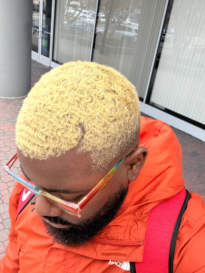 From above: short waves lightened to a bright yellow blonde, cut close at the sides